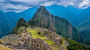 The classic panoramic view of the ancient Inca citadel of Machu Picchu, nestled among the Andes mountains with Huayna Picchu peak rising dramatically in the background – Qosqo Expeditions