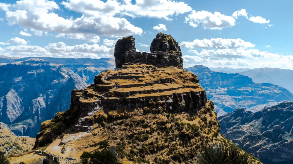The ancient fortress of Waqrapukara, known for its horn-shaped peak and Inca terraces, perched high above a deep Andean canyon in Peru. – Qosqo Expeditions