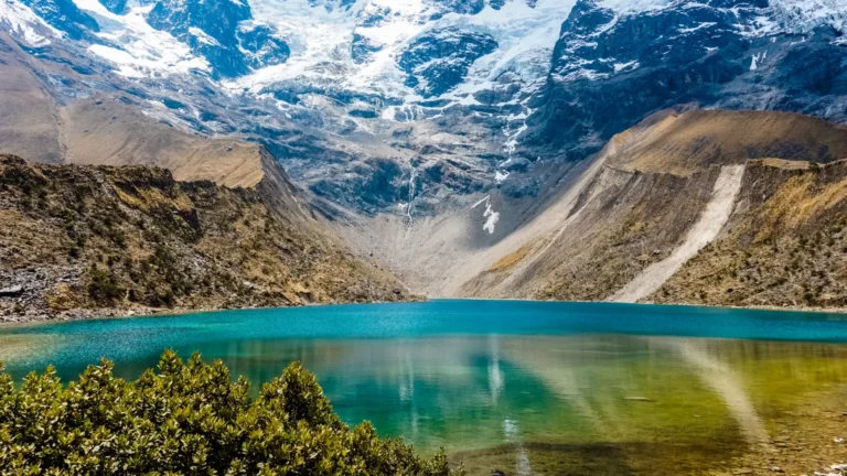 The tranquil, turquoise waters of Humantay Lake in Cusco, with the massive, snow-covered Humantay glacier rising directly from its shore. – Qosqo Expeditions