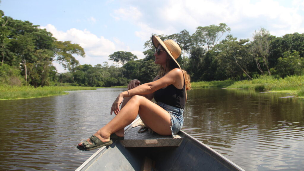 A woman on a boat tour in the Amazon, the first stage of her exclusive Amazon to Andes itinerary – Qosqo Expeditions

