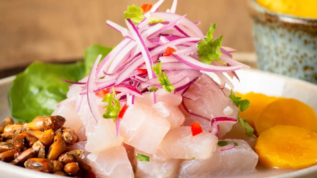 Peruvian ceviche with fresh fish, red onion, chili, sweet potato, and roasted corn served on a traditional Andean plate-Qosqo Expeditions