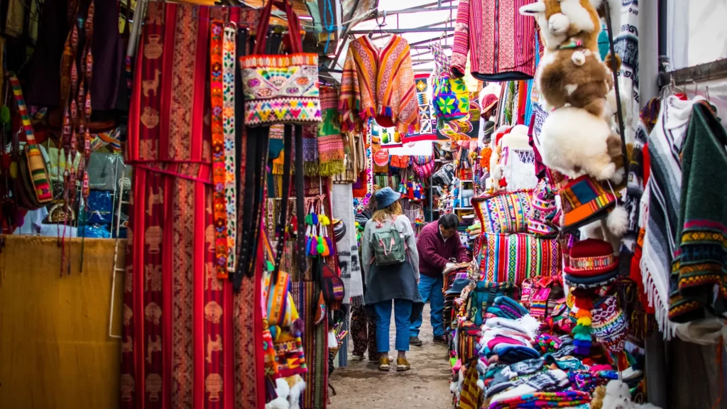 Busy artisan market in Cusco with colorful woven bags blankets handmade toys and traditional clothing