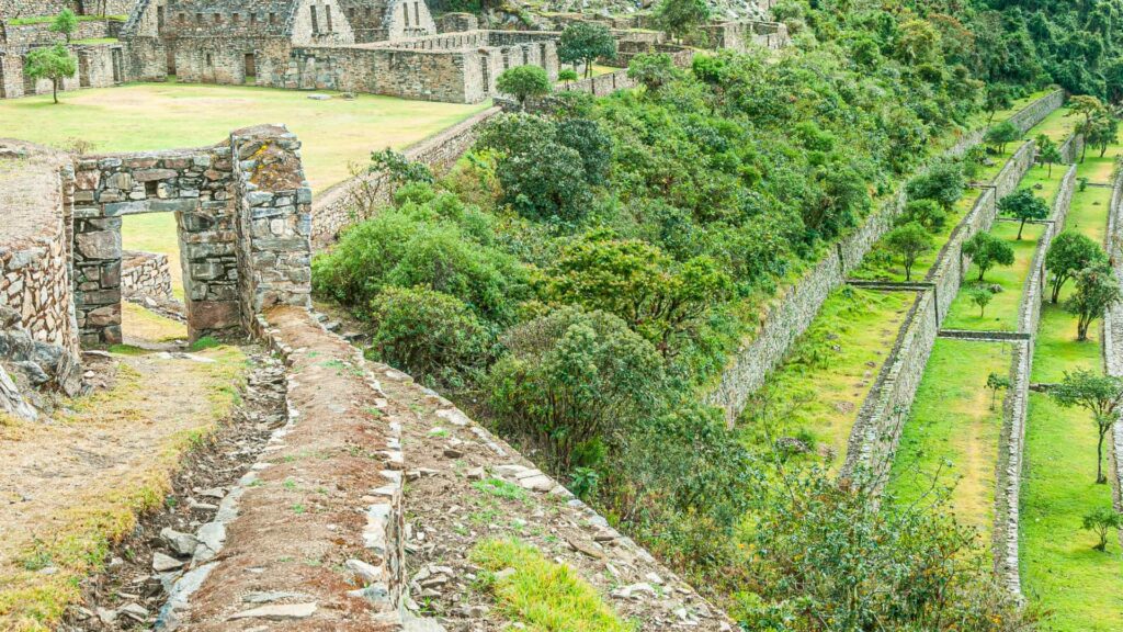 Stone doorway and terraces at Choquequirao surrounded by lush mountains featured in the Choquequirao trek Peru experience.-Qosqo Expeditions
