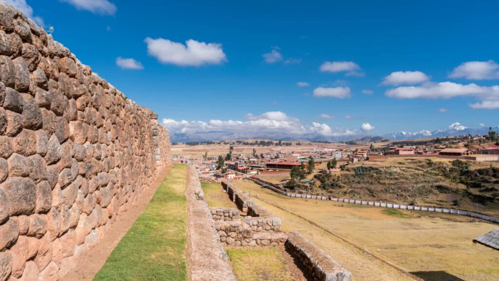 Panoramic view of Inca stone walls and terraces overlooking a valley town—an example of heritage in the Andean highlands Peru.-Qosqo Expeditions