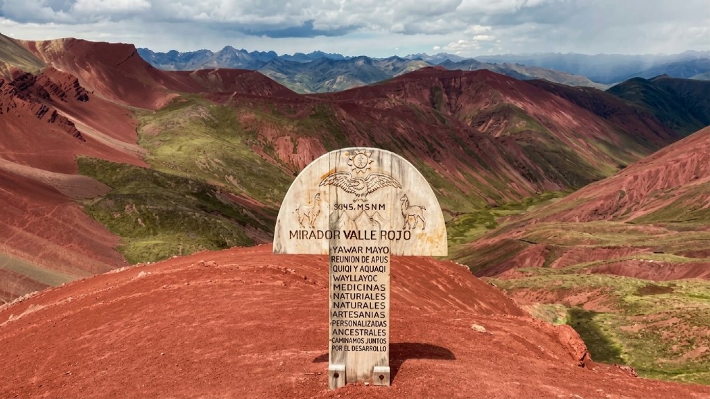Wooden viewpoint sign overlooking the panoramic landscapes of Red Valley Cusco.